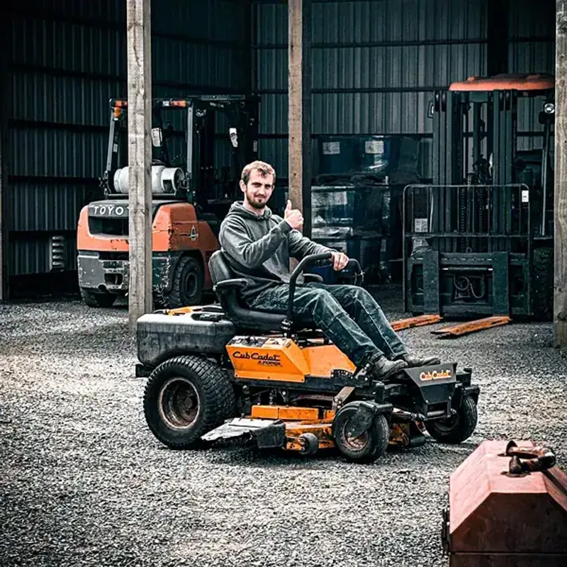 Man on lawn mower giving a thumbs up